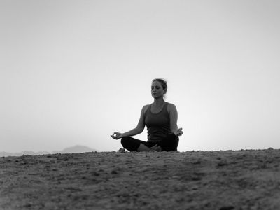 Silhouette of a person doing yoga against a window